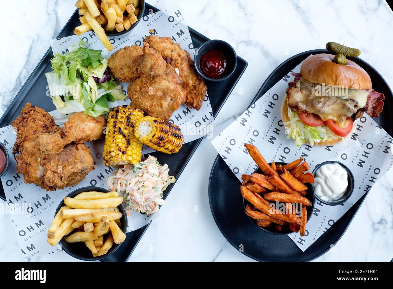 Sheffield, UK - 03 Aug 2017: Burger & friesa & a southern fried chicken share platter with coleslaw and sweetcorn at OHM, Fitzwilliam Street Stock Photo