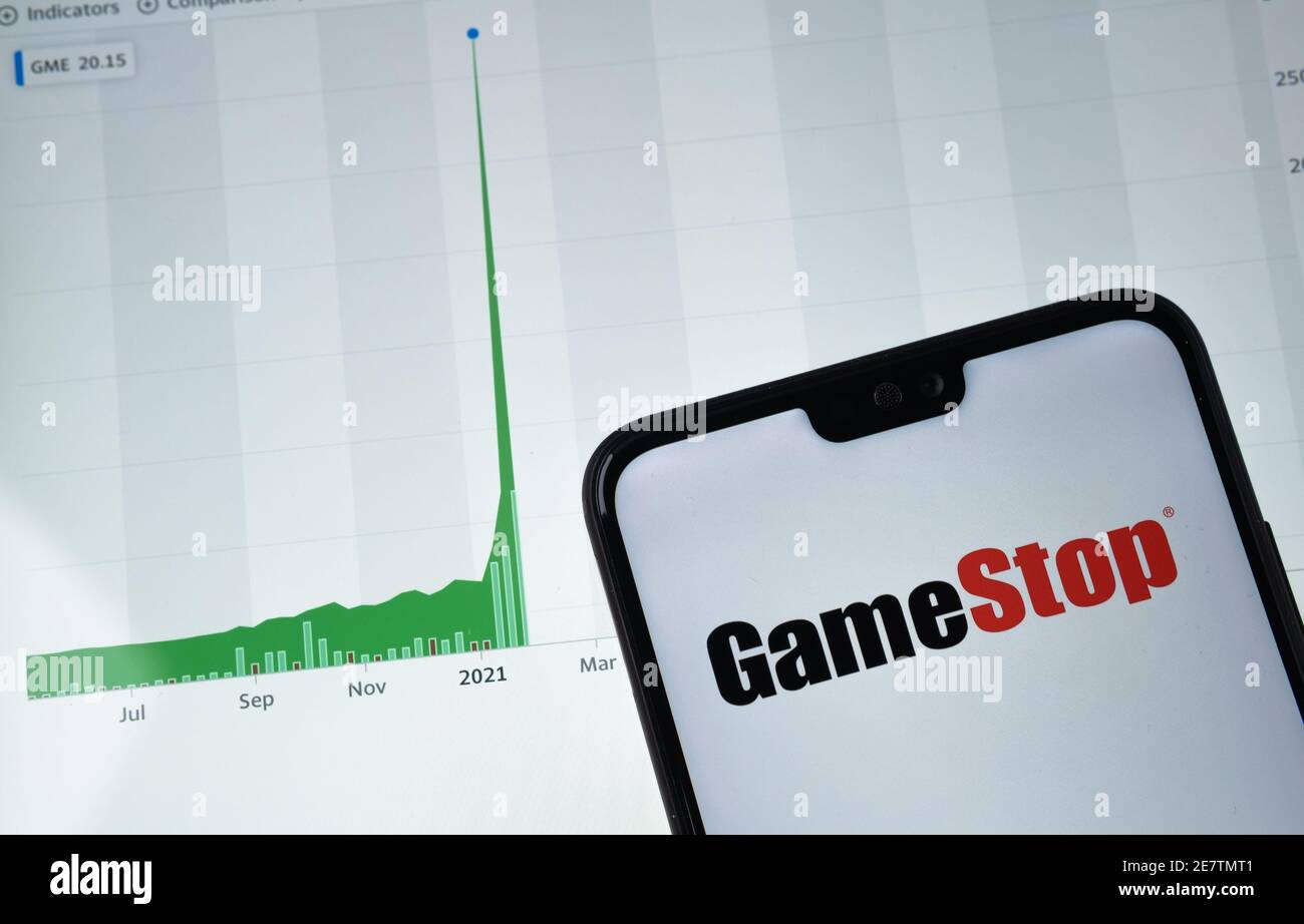 GameStop logo seen on the smartphone screen and real GameStop stock