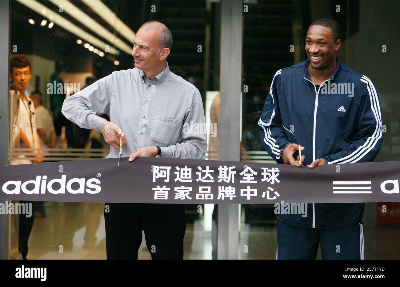 Erich Stamminger (L), President and CEO of the Adidas brand, and NBA's  Washington Wizards guard Gilbert Arenas cut the ribbon during the opening  ceremony of the new and the largest Adidas store