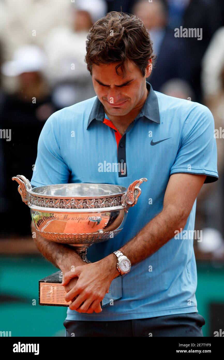 Roger Federer of Switzerland cries as he receives his trophy during the  presentation ceremony after winning the men's final against Robin Soderling  of Sweden at the French Open tennis tournament at Roland