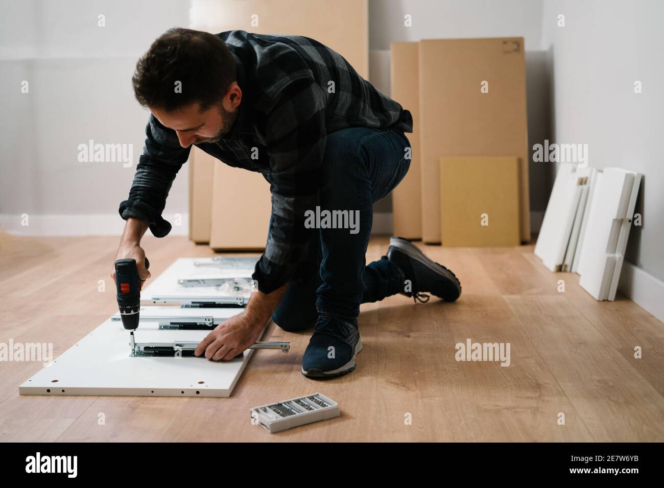 Portrait of man assembling furniture. Do it yourself furniture assembly. Stock Photo