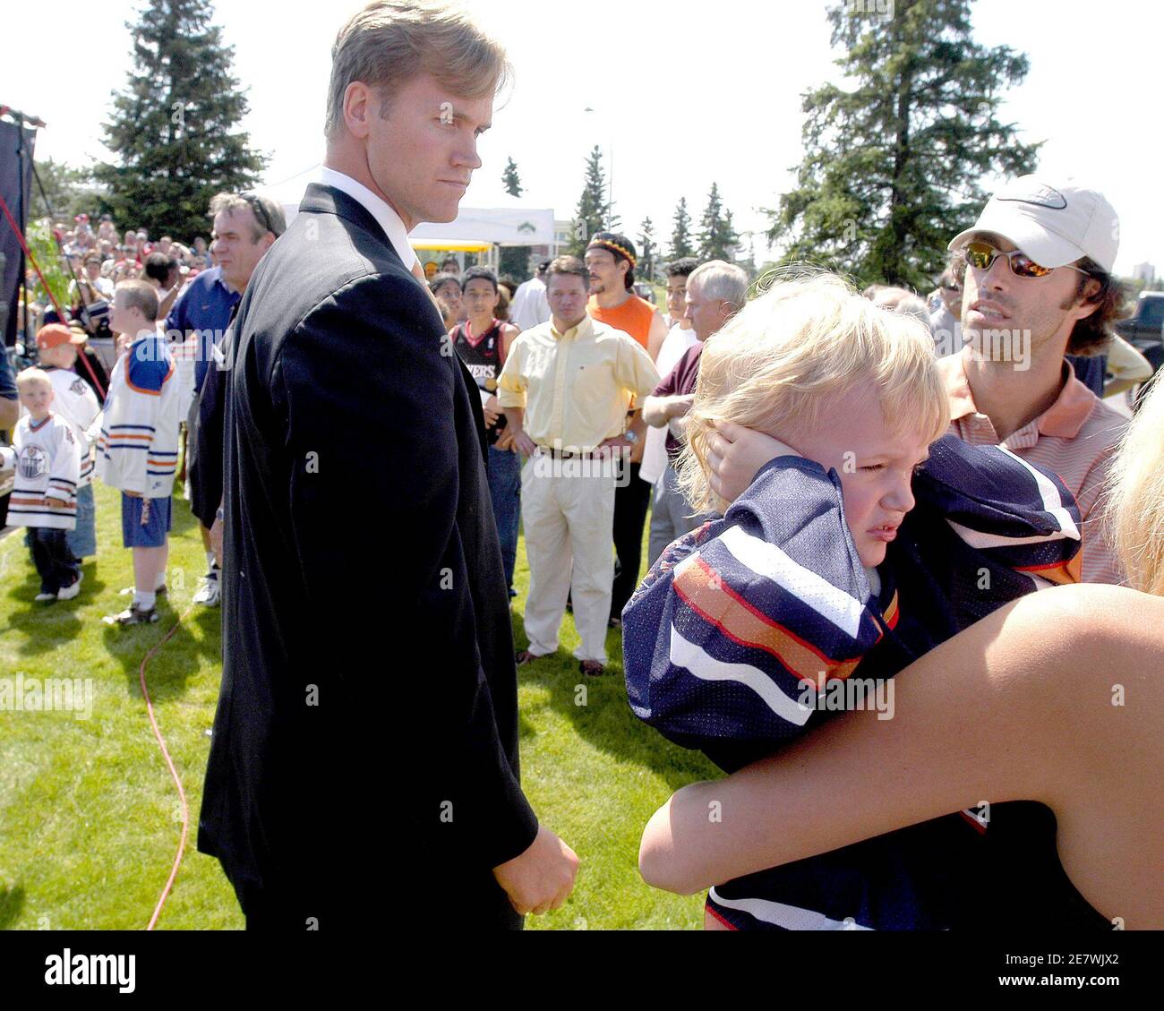 newly-acquired-defenseman-chris-pronger-l-watches-his-son-jack-pronger-3-cover-his-ears-from-the-noise-of-hundreds-of-screaming-fans-outside-the-edmonton-oilers-offices-during-a-news-conference-in-edmonton-canada-august-5-2005-pronger-and-mike-peca-r-with-sunglasses-received-their-new-team-jerseys-before-answering-reporters-questions-and-mingling-with-fans-prongers-wife-lauren-is-holding-the-child-reutersdan-riedlhuber-drjj-2E7WJX2.jpg