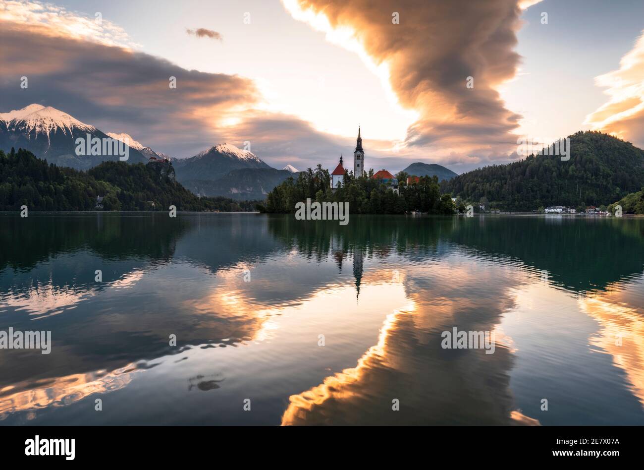 Sunrise reflections and the church Our Lady of the Lake, on Lake Bled, Slovenia Stock Photo