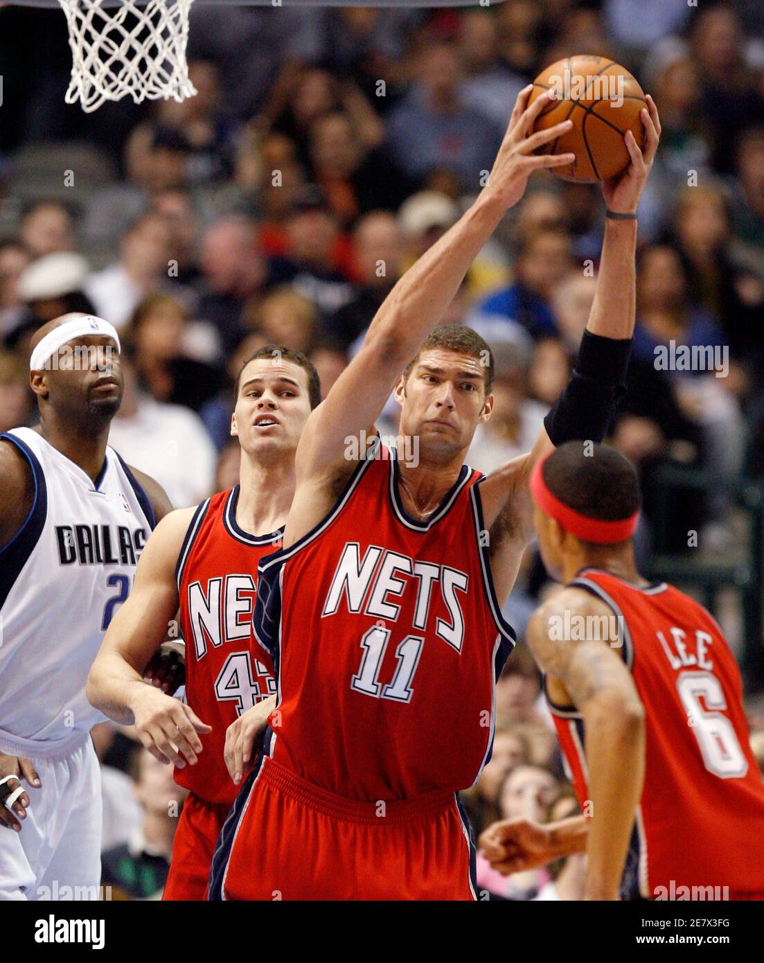 New Jersey Nets center Brook Lopez (2nd R) grabs a defensive rebound as  Dallas Mavericks center Erick Dampier (L) forward Kris Humphries (2nd L)  and guard Courtney Lee watch during the first