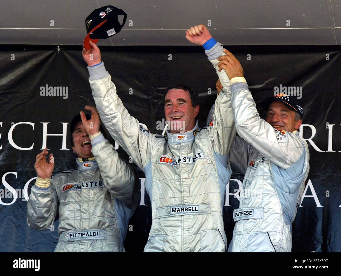 Briton Nigel Mansell (C), Brazil's Emerson Fittipaldi (L) and Italy's Ricardo Patrese celebrate after the Grand Prix Masters race at the Kyalami circuit near Johannesburg November 13, 2005. Mansell, 52, led the 30-lap race from start to finish and held off the challenge of Fittipaldi to win by less than half-a-second. REUTERS/Juda Ngwenya Stock Photo