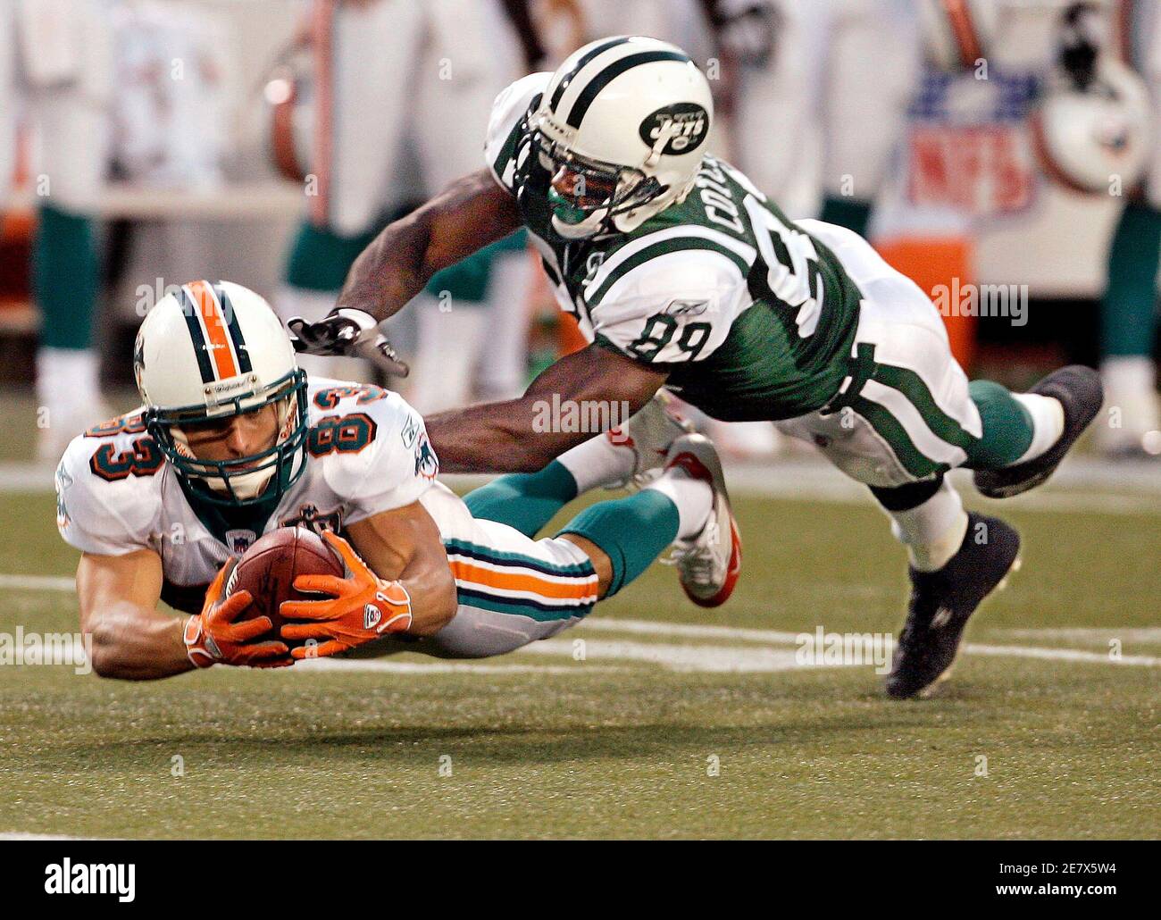 Miami Dolphins Wes Welker (83) outreaches New York Jets Jerricho Cotchery  (89) to recover his own fumble after he called a fair catch and then  fumbled it on a punt in the