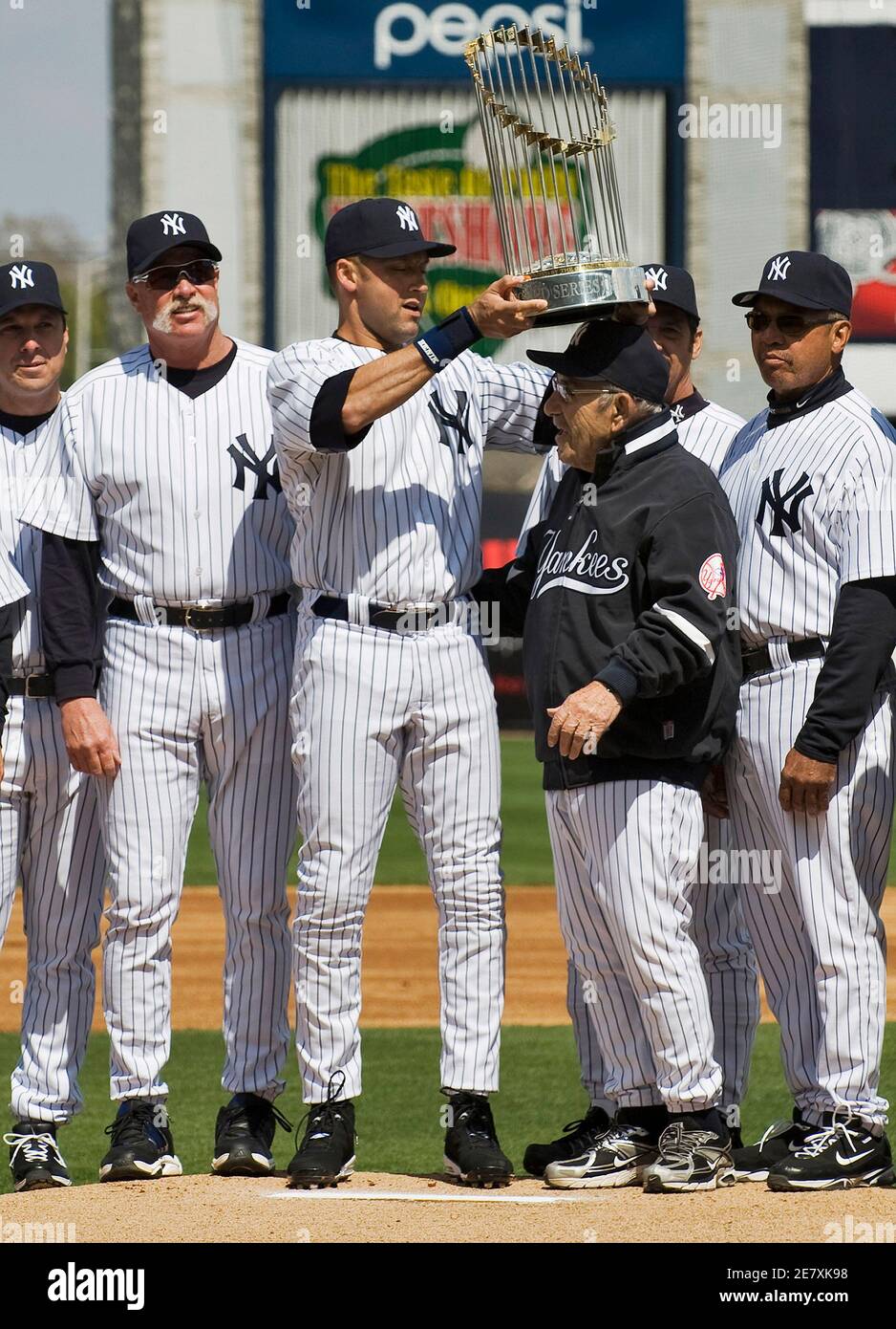 Former New York Yankees Tino Martinez L Goose Gossage 2nd L And Reggie Jackson R Look On As Derek Jeter C Lifts The 09 World Series Championship Trophy Above Yogi Berra S Head