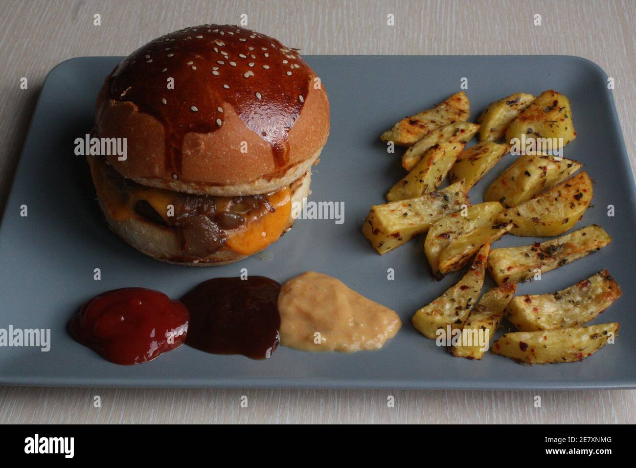 homemade hamburger with baked potatoes, grilled beef. some areas are out of focus. selective focuse on hamburger Stock Photo