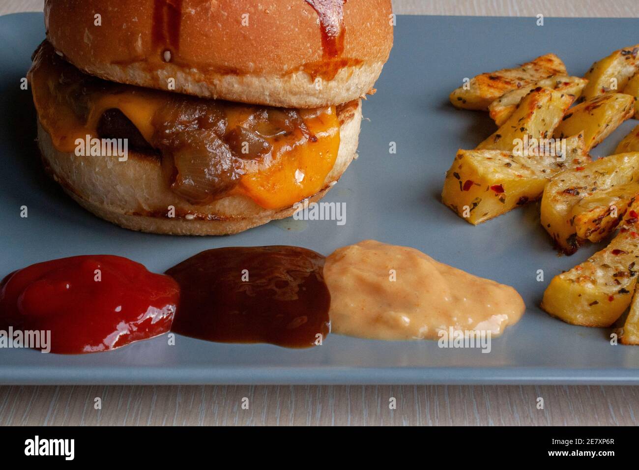 homemade hamburger with baked potatoes, grilled beef. some areas are out of focus. selective focuse on hamburger Stock Photo