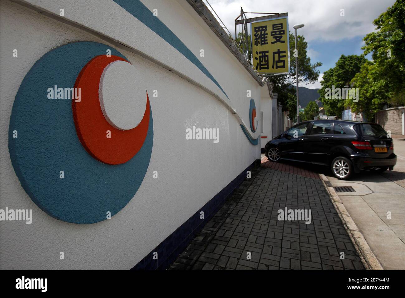 A car enters a motel, the former home of the late kung fu star Bruce Lee, in Hong Kong's Kowloon Tong district July 20, 2009. The billionaire owner of Lee's final home hopes to build a museum to the martial arts legend, giving in to public calls to prevent the sale of the luxury house in a northern Hong Kong suburb for millions of dollars. The Hong Kong government has launched a competition where the public has been invited to submit ideas and concepts for restoring the two storey house in Kowloon.   REUTERS/Tyrone Siu   (CHINA POLITICS ENTERTAINMENT) Stock Photo