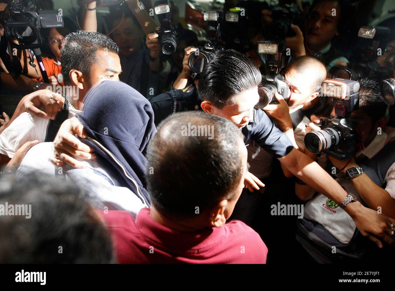 One of the two policemen (face covered), found guilty of the murder of a Mongolian model, is being escorted to a police van at Shah Alam high court, on the outskirts of Kuala Lumpur April 9, 2009. Two Malaysian policemen have been found guilty of the lurid murder, a case that has ensnared the country's new prime minister, and will be hung, a court said on Thursday. REUTERS/Zainal Abd Halim (MALAYSIA CONFLICT SOCIETY POLITICS) Stock Photo