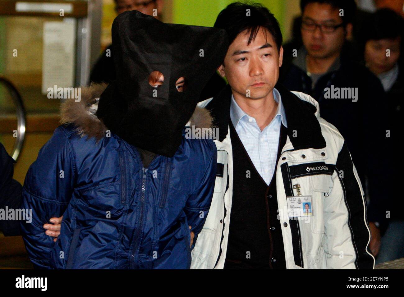 A suspect (L) related to one of the acid attacks is taken away by the police in Hong Kong January 13, 2010. Government radio reported on Wednesday two men have been arrested in connection with an acid attack in Causeway Bay last month, in which six people were injured, with two seriously. Over 100 people have been injured in six of such attacks, spanning several shopping districts in the territory since December 2008.   REUTERS/Tyrone Siu     (CHINA - Tags: CRIME LAW) Stock Photo