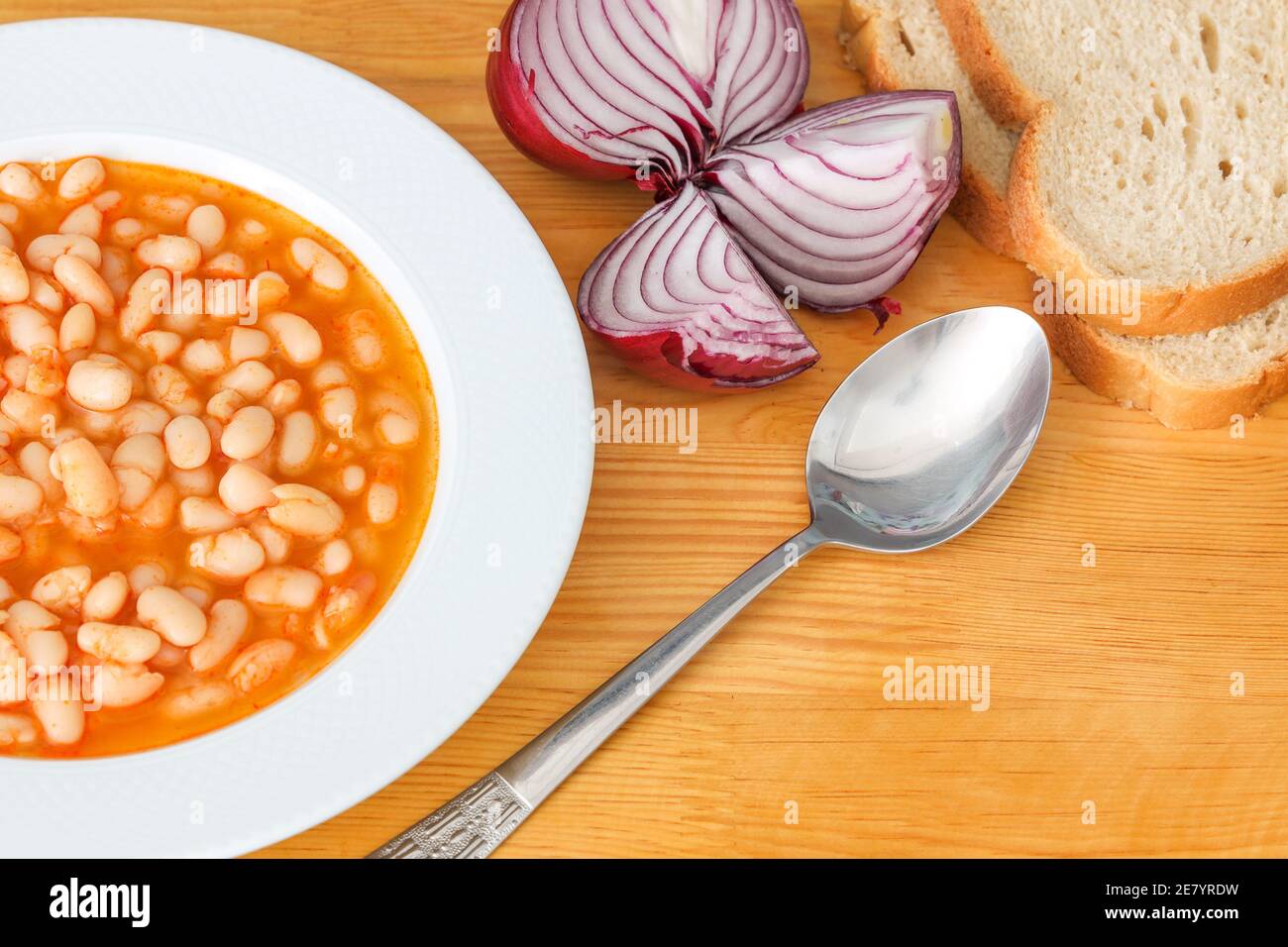 Traditional Turkish Haricot bean food served with onion and bread on wooden background. Stock Photo