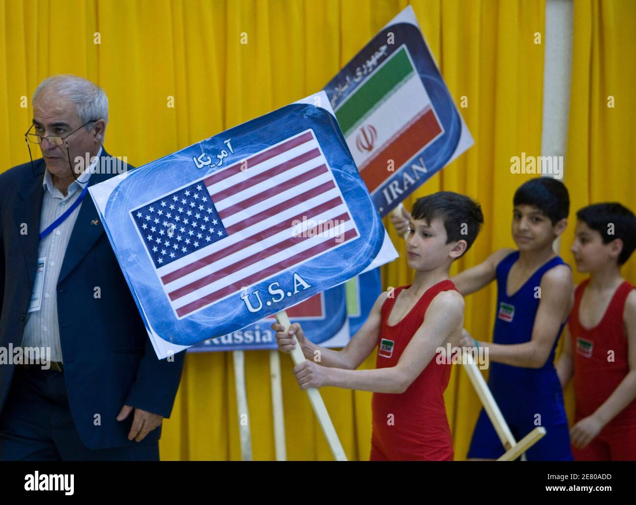 Iranian boys carry placards of Iran and United States during the opening ceremony of the 29th Takhti Free Style Wrestling Tournament in Tehran March 12, 2009. REUTERS/Raheb Homavandi (IRAN SPORT WRESTLING POLITICS) Stock Photo