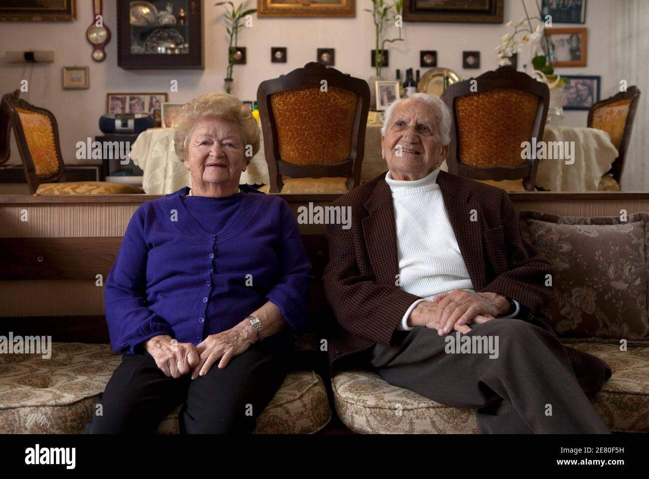 Holocaust survivors Yitzhak and Rina Birnhak, both Polish-born, sit in their home in the northern city of Haifa, ahead of Israel's Holocaust Remembrance Day, April 9, 2010. Yitzhak and Rina met in Krakow, Poland during World War Two and were among more than 1,000 Jews taken in by German industrialist Oskar Schindler. Spared death thanks to Schindler's insistence that German authorities leave them in his employ -- their names appeared on the now-famous 'Schindler's List' -- rather than deport them to concentration camps. The couple wed in British-ruled Palestine in 1946 and today have two child Stock Photo