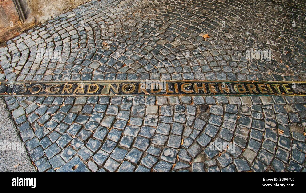 A line on the cobblestones of Rüsselsheim Castle marks the place where the 50th parallel north runs Translation: 50th degree northern latitude Stock Photo