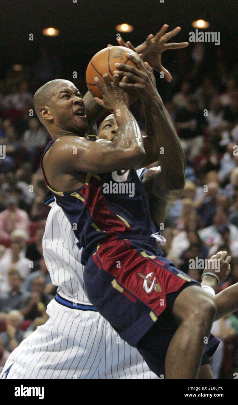 Cleveland Cavaliers' guard Eric Snow (front) is fouled by Orlando Magic defender Dwight Howard during NBA play in Orlando, Florida March 10, 2006. Orlando won the game 102-73. REUTERS/Rick Fowler Stock Photo