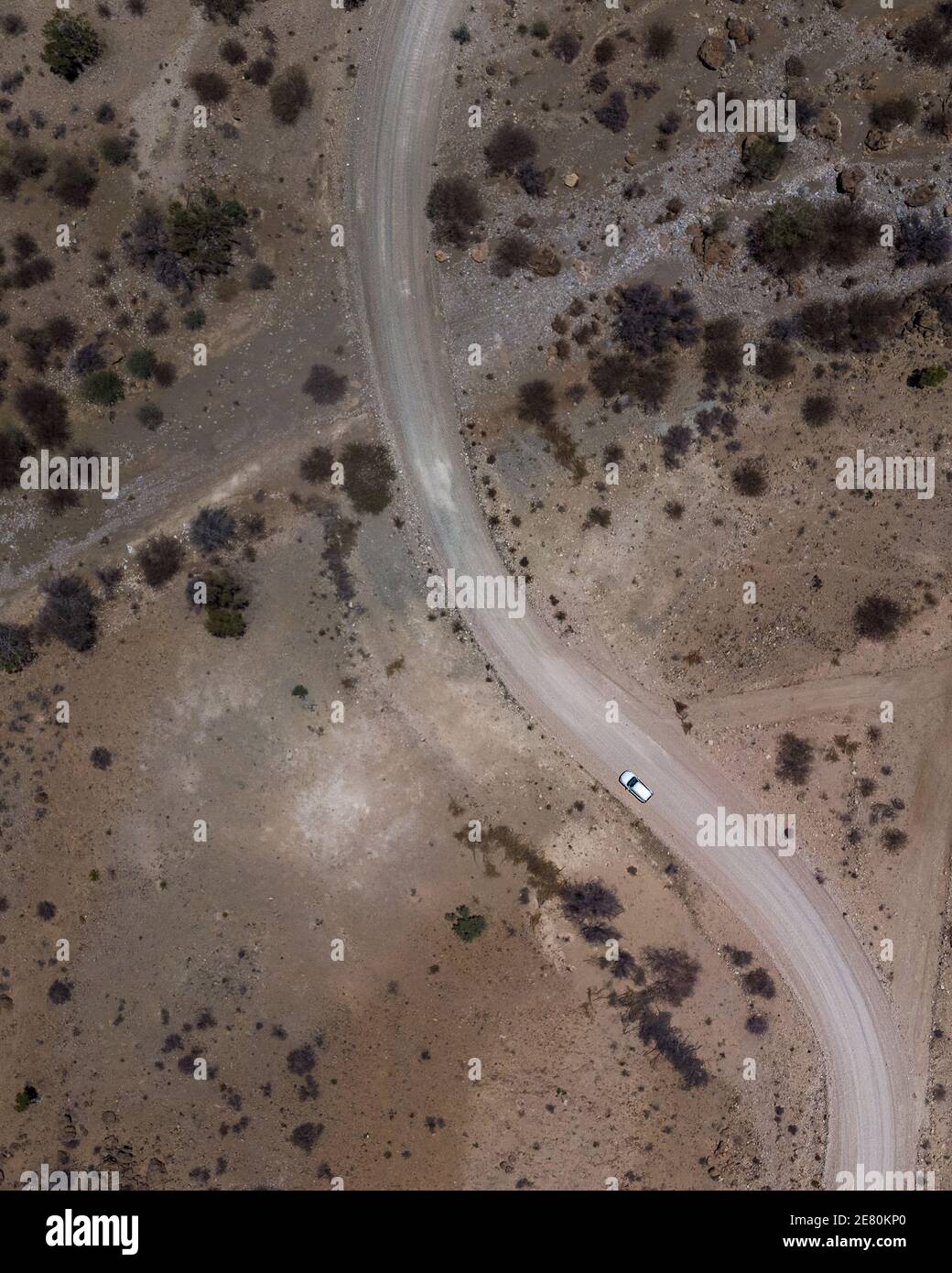 Aerial view of a car driving along a winding road in a desert Stock ...