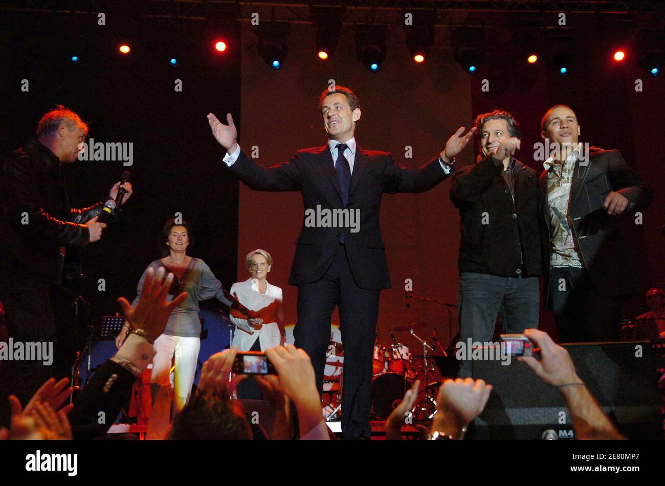 France's newly-elected president Nicolas Sarkozy waves the crowd alongside actor Christian Clavier and singer Faudel, Place de la Concorde in Paris, France, May 6, 2007. French voters elected reform-minded Nicolas Sarkozy as their new president on Sunday, giving him a comfortable winning margin, preliminary official results and projections from four polling agencies showed. With more than half of the vote counted, Sarkozy was scoring just over 53 percent to a little more than 46 percent for Socialist Segolene Royal. Polling agencies also had the conservative Sarkozy winning 53 percent of the v Stock Photo