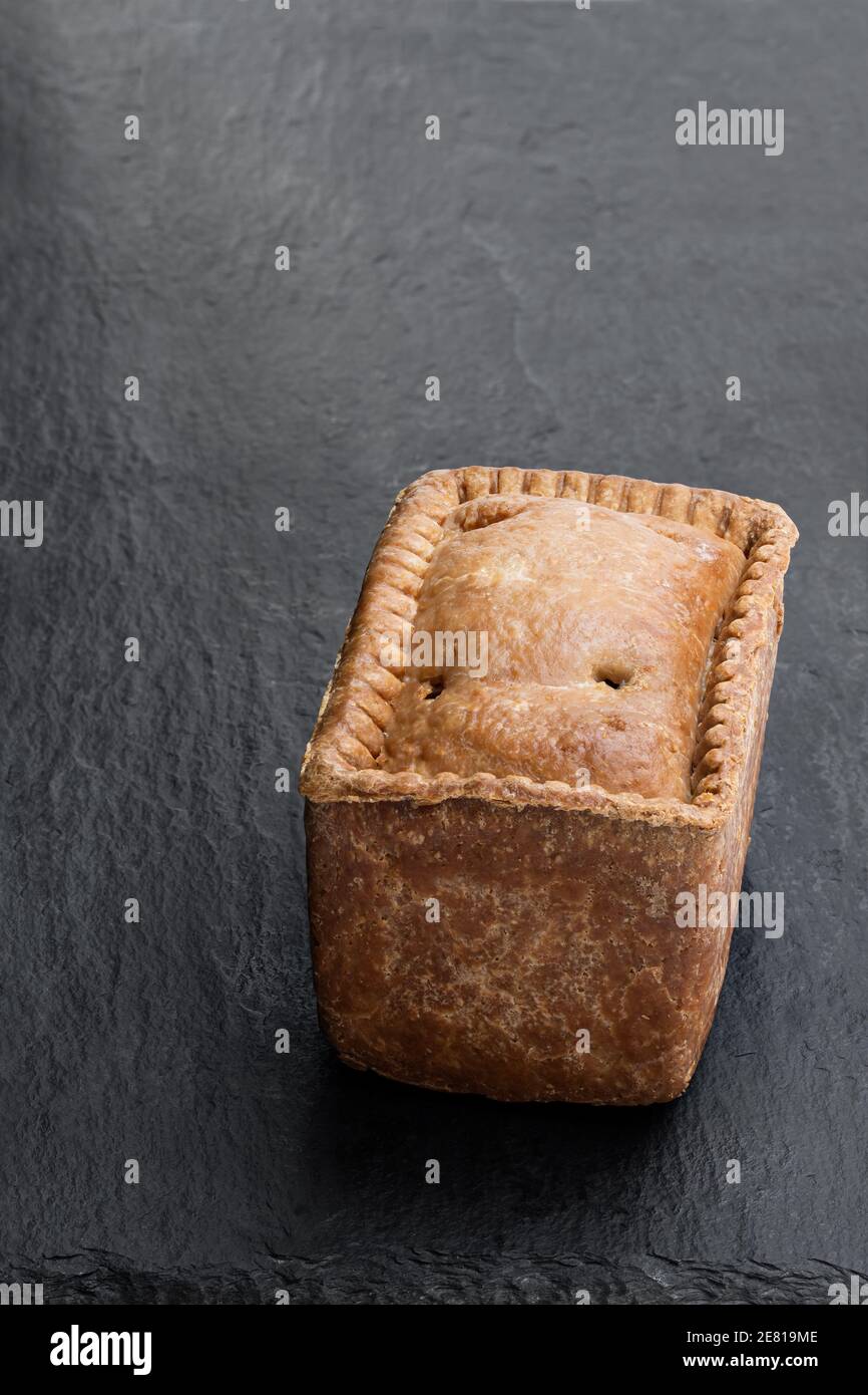 Traditional English savoury gala egg pork pie on stone background Stock