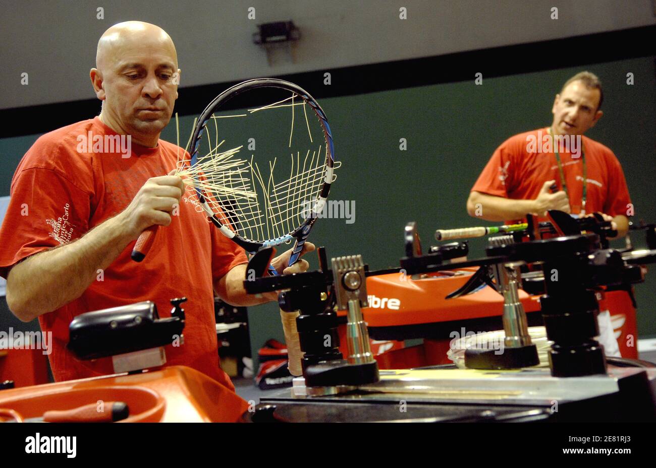 Specialized workers prepare stringing of tennis player's rackets before ...