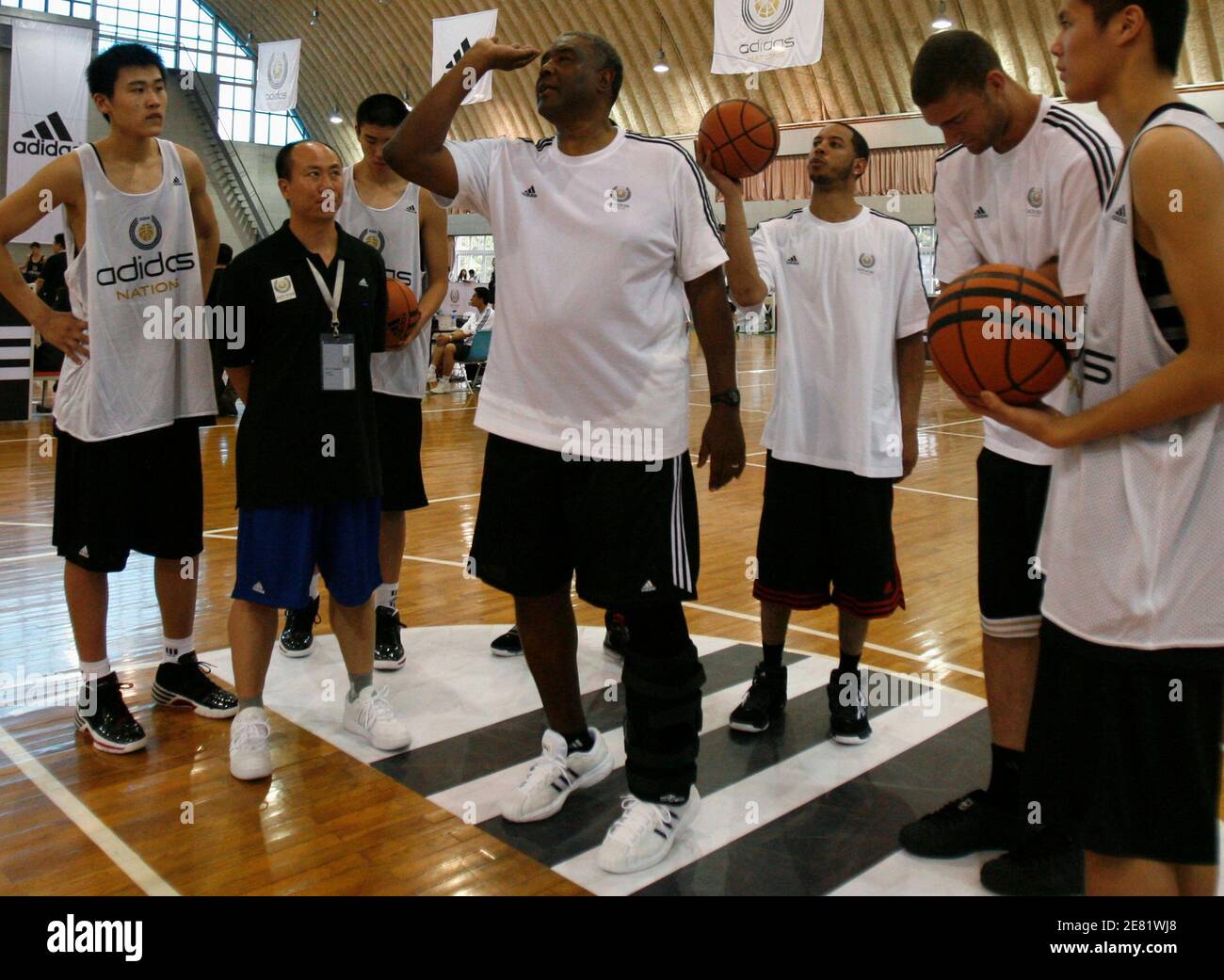 Paul Silas (C), the former coach of the Cleveland Cavaliers, demonstrates  how to shoot a basket during the Adidas training camp in Beijing May 19,  2009. Lebron James has become such a