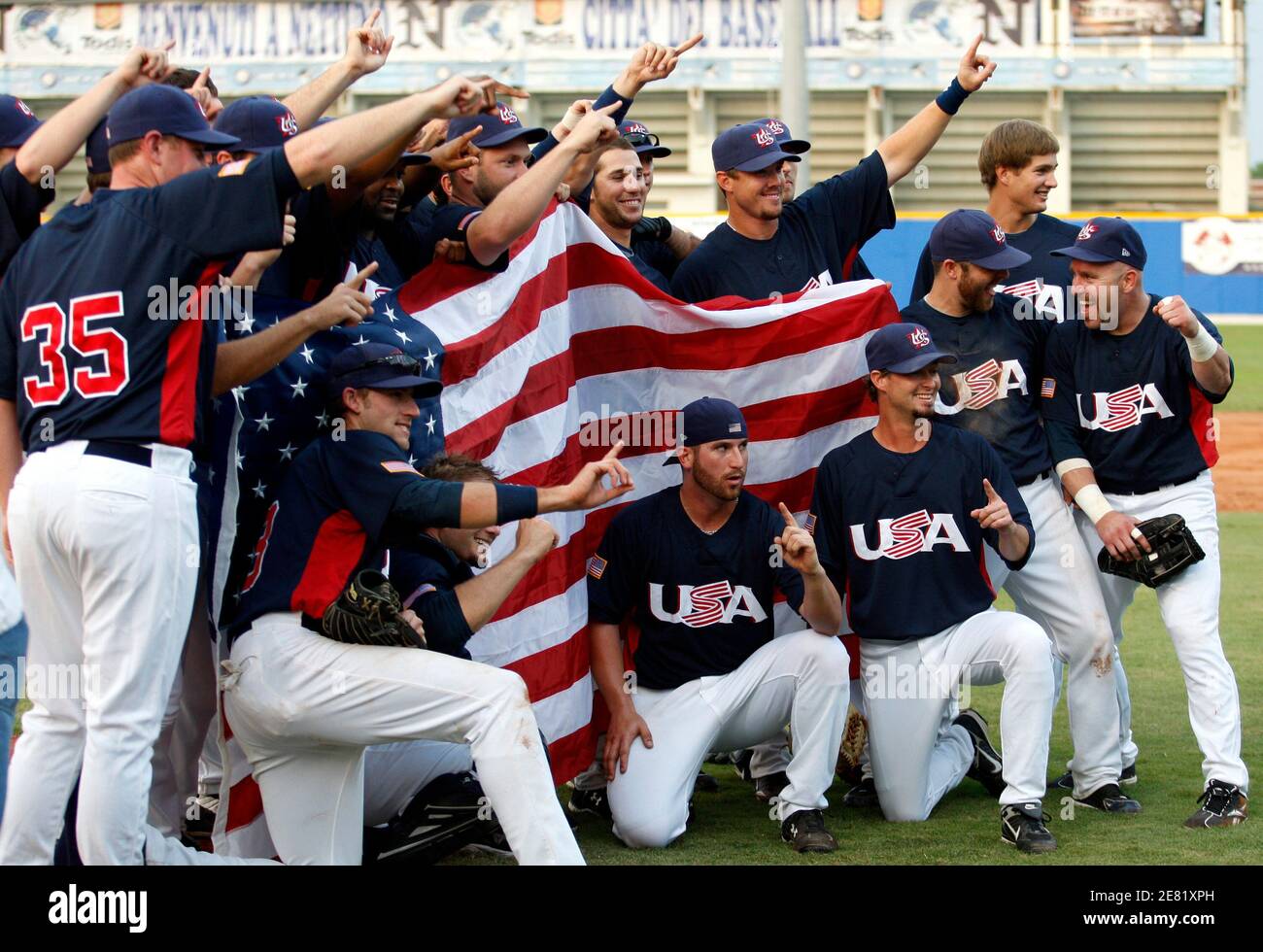 Members of the U.S. national baseball team pose with the national flag  after winning their IBAF World Cup 2009 baseball final game against Cuba at  the Steno Borghese Stadium in Nettuno, near