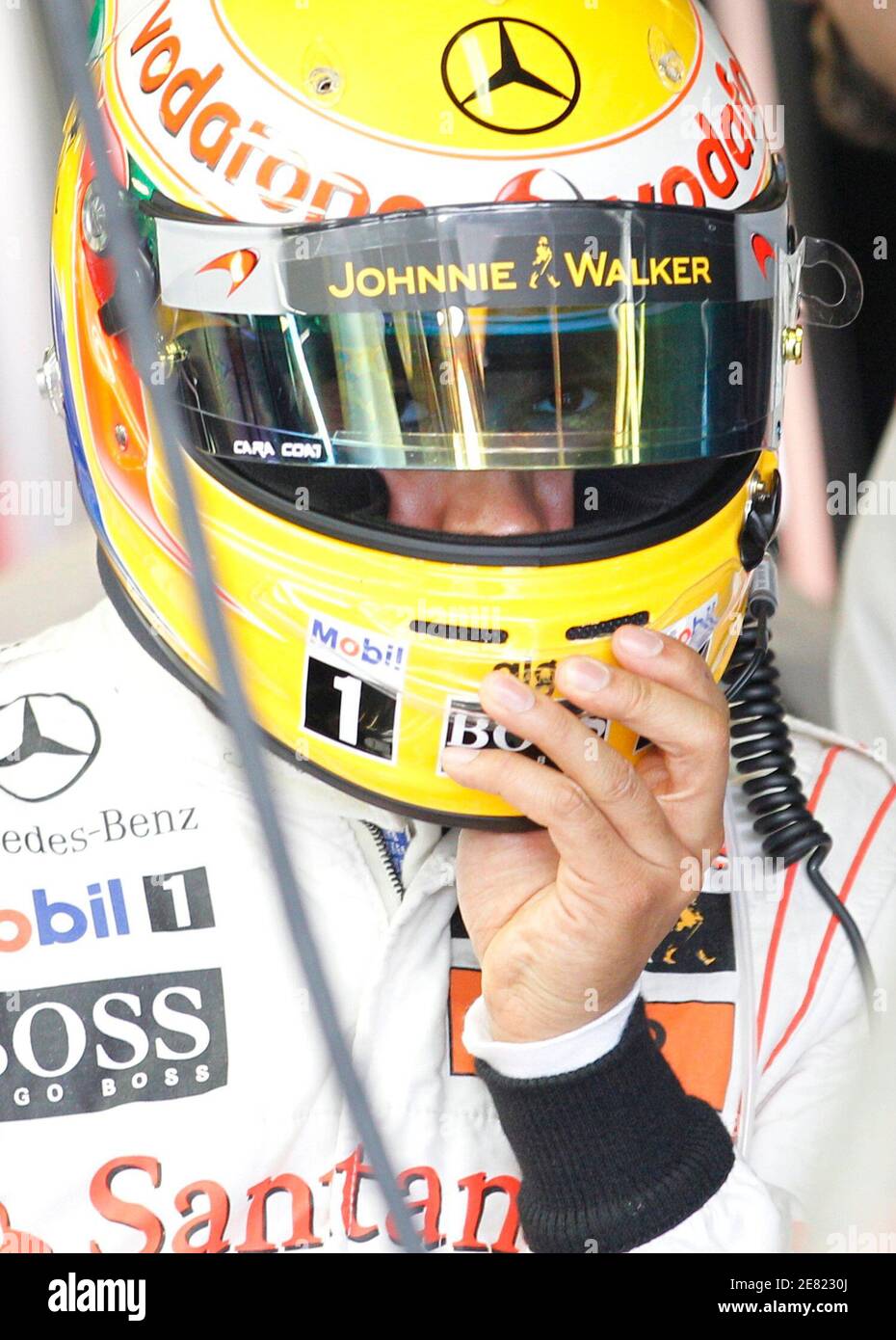 McLaren Formula One driver Lewis Hamilton of Britain removes his helmet  during qualifying at the Australian F1 Grand Prix in Melbourne March 27,  2010. REUTERS/Mark Horsburgh (AUSTRALIA - Tags: SPORT MOTOR RACING