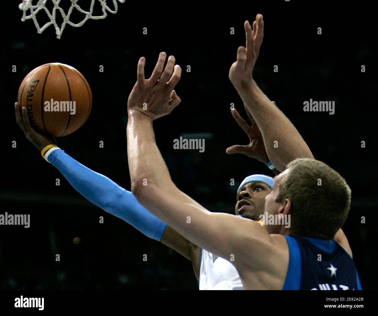 Denver Nuggets guard Allen Iverson (L) shoots past Dallas Mavericks forward Dirk Nowitzki in the first quarter of their NBA basketball game in Denver, Colorado April 6, 2007. REUTERS/Rick Wilking (UNITED STATES) Stock Photo