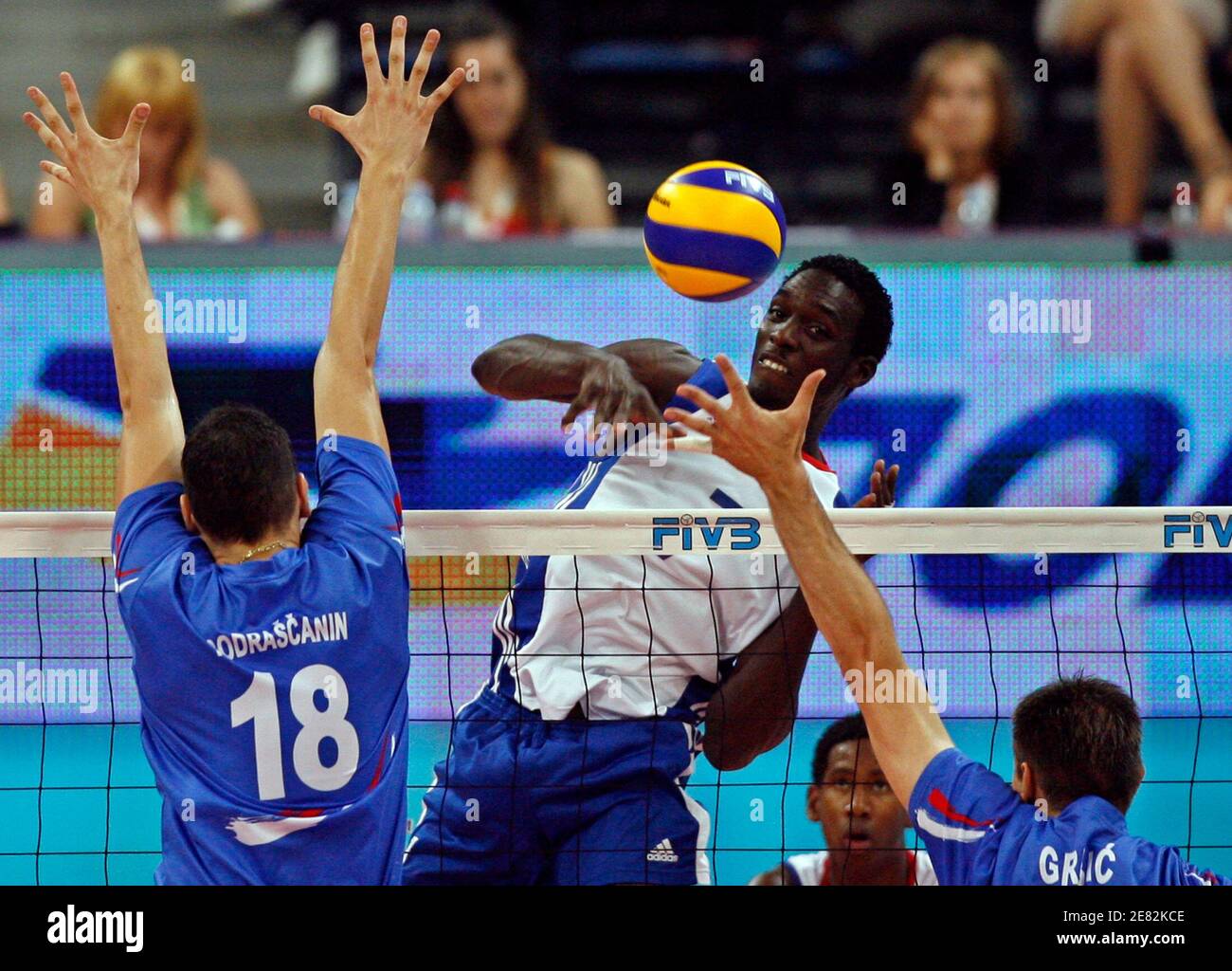 Cuba's Durruty Osmany Camejo (C) spikes the ball against Serbia's Marko Podrascanin (L) and Nikola Grbic during their men's World League 2009 final round volleyball match in Belgrade July 25, 2009.  REUTERS/Ivan Milutinovic (SERBIA SPORT VOLLEYBALL) Stock Photo