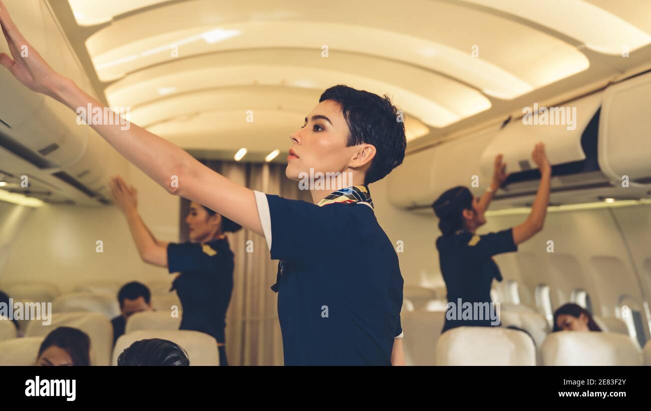 Cabin Crew Lift Luggage Bag In Airplane Airline Transportation And Tourism Concept Stock Photo Alamy