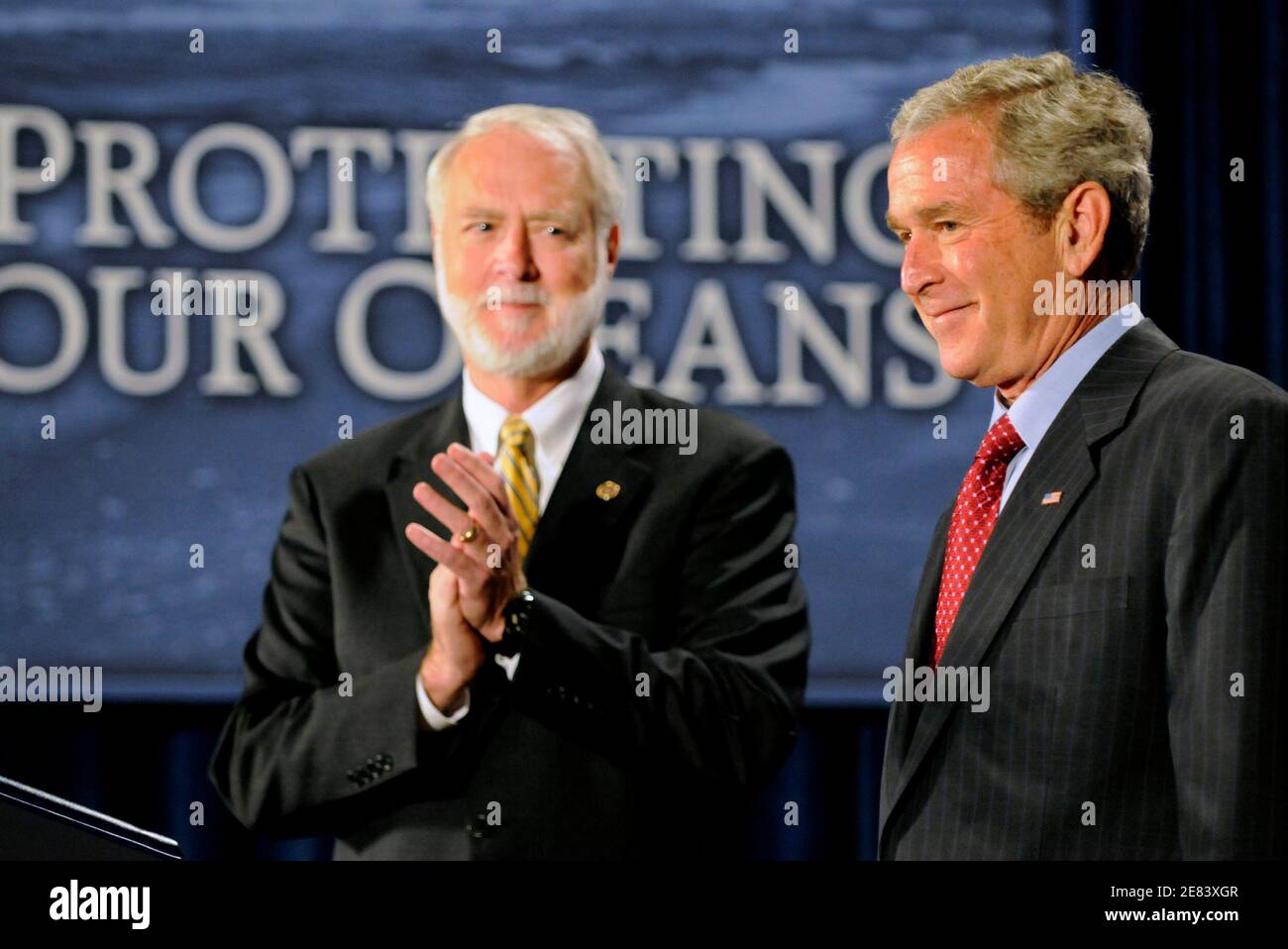 U.S. President George W. Bush (R) is applauded by Smithsonian Institute Secretary Wayne Clough prior to making remarks on U.S. Ocean Action Plan at the Smithsonian Museum of Natural History in Washington September 26, 2008. REUTERS/Mike Theiler  (UNITED STATES) Stock Photo