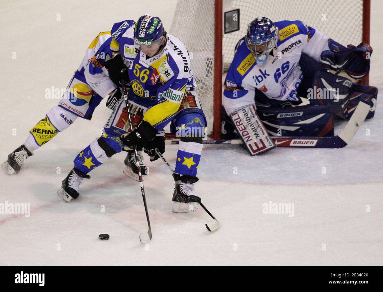 HC Davos Dino Wieser (C) shields the puck from ZSC Lions Marc Welti as  goaltender Roni Hueger watches during their Swiss ice hockey play-off final  game in Davos April 11, 2009. REUTERS/Miro