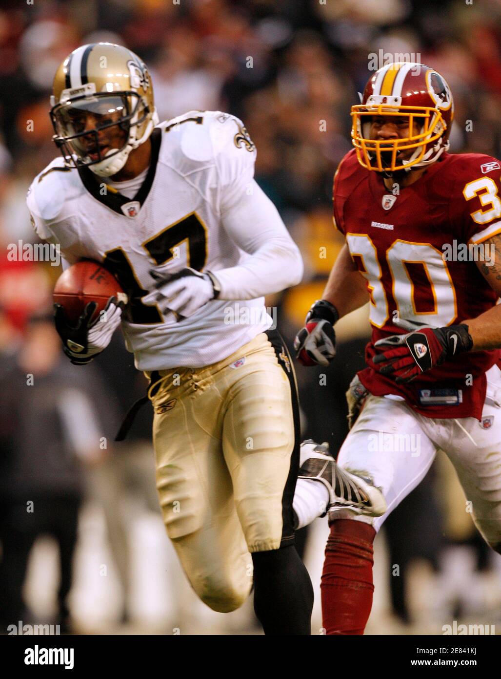 New Orleans Saints receiver Robert Meachem (L) catches a touchdown pass that tied the game from quarterback Drew Brees (not in photo) in the fourth quarter of their NFL football game against the Washington Redskins in Landover, Maryland December 6, 2009. Redskins' safety LaRon Landry (R) pursues on the play. The Saints' won the game in overtime on a field goal.    REUTERS/Gary Cameron               (UNITED STATES SPORT FOOTBALL) Stock Photo