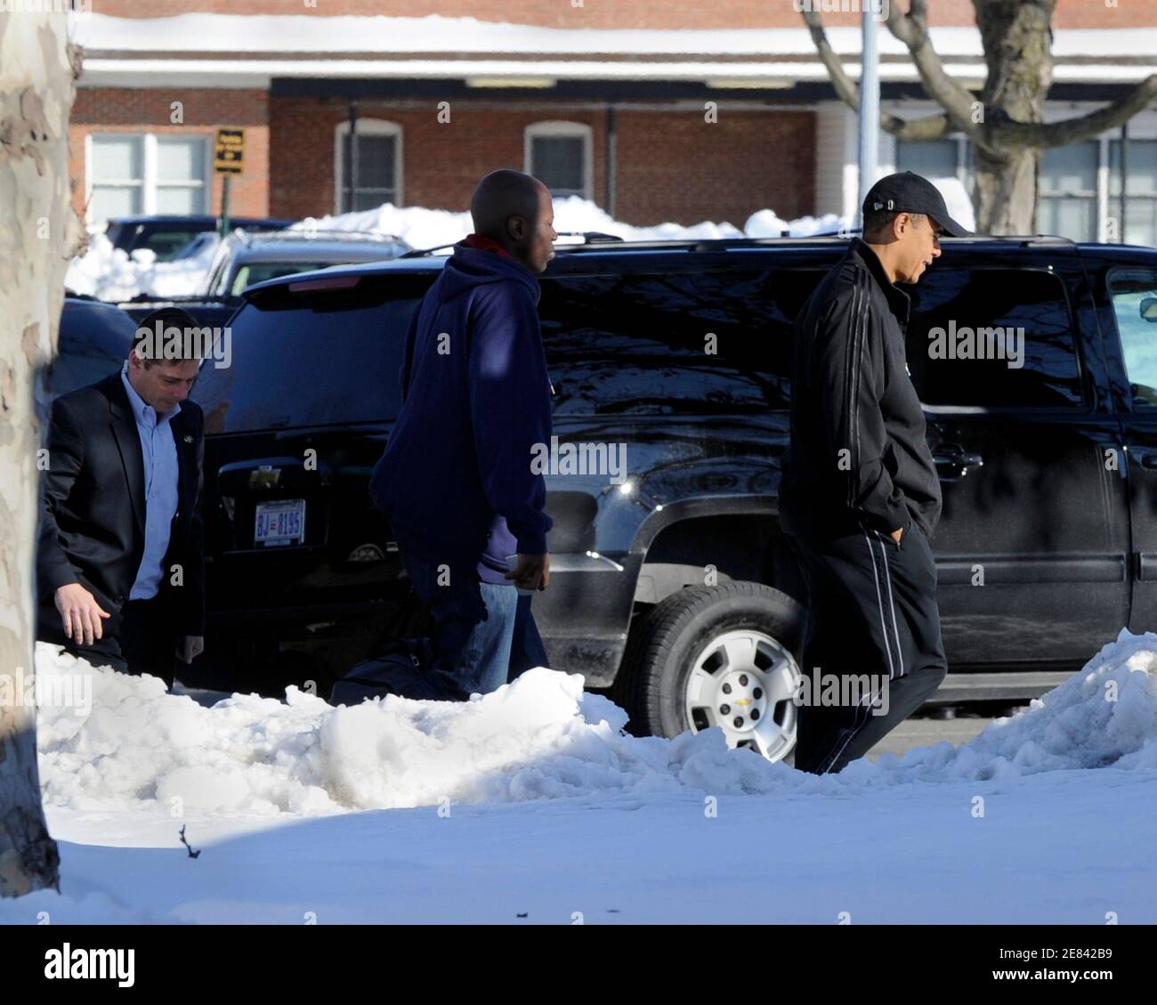U.S. President Barack Obama (R), dressed in a track suit, walks in front of presidential aide Reggie Love as they arrive at the Physical Fitness Center to play basketball at Ft. McNair in Washington, DC, February 14, 2010.  REUTERS/Mike Theiler (UNITED STATES - Tags: POLITICS SPORT BASKETBALL) Stock Photo