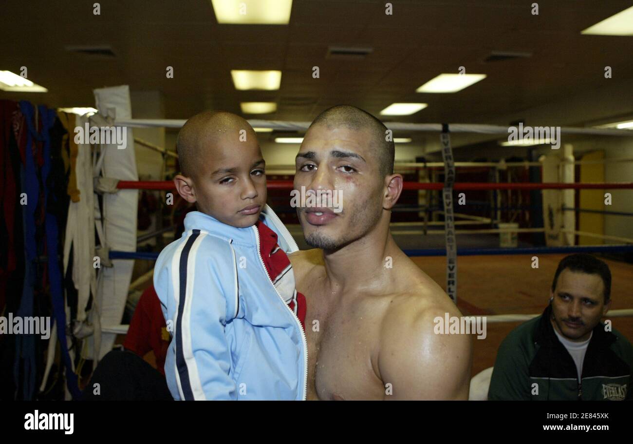 Boxer Miguel Cotto of Puerto Rico and his son Miguel Jr. pose for  photographers at Cotto's training camp in New York June 4, 2006. Cotto, the  WBO Jr. Welterweight champion, will fight