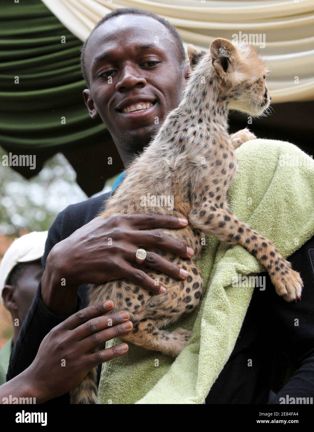 Olympic and world sprint champion Usain Bolt of Jamaica holds a three-month  old cheetah at the Kenya Wildlife Service (KWS) headquarters in Kenya's  capital Nairobi November 2, 2009. Bolt adopted the male
