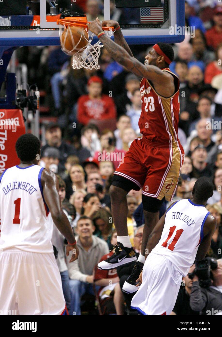 Cleveland Cavaliers forward LeBron James (23) dunks between the defense of  Philadelphia 76ers guard Jrue Holiday (11) and 76ers center Samuel  Dalembert (1) during the fourth quarter of NBA basketball action in