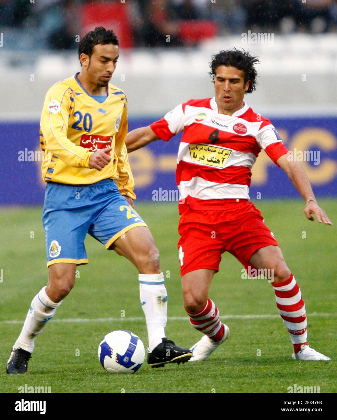 Alireza Mohammad (R) of Iran's Piroozi fights for the ball with Otman El Assas of Qatar's Al-Gharafa during their AFC Champions League soccer match at Tehran's Azadi stadium April 8, 2009. REUTERS/Raheb Homavandi (IRAN SPORT SOCCER) Stock Photo