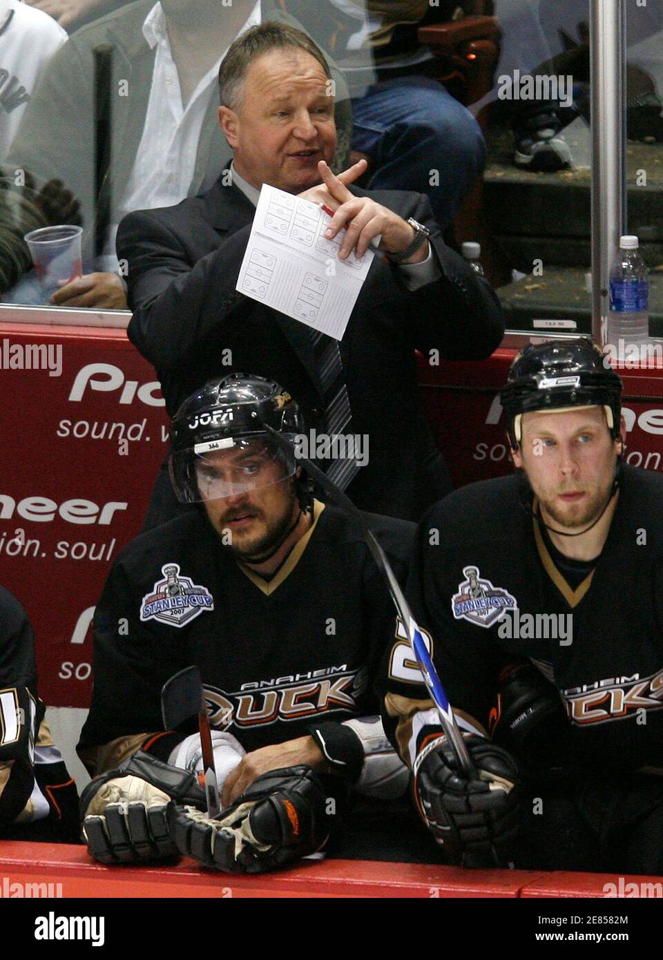 Anaheim Ducks coach Randy Carlyle (C) gives instructions to his team behind  players Teemu Selanne (L) and Tavis Moen in the second period during Game 1  of the 2007 Stanley Cup Finals