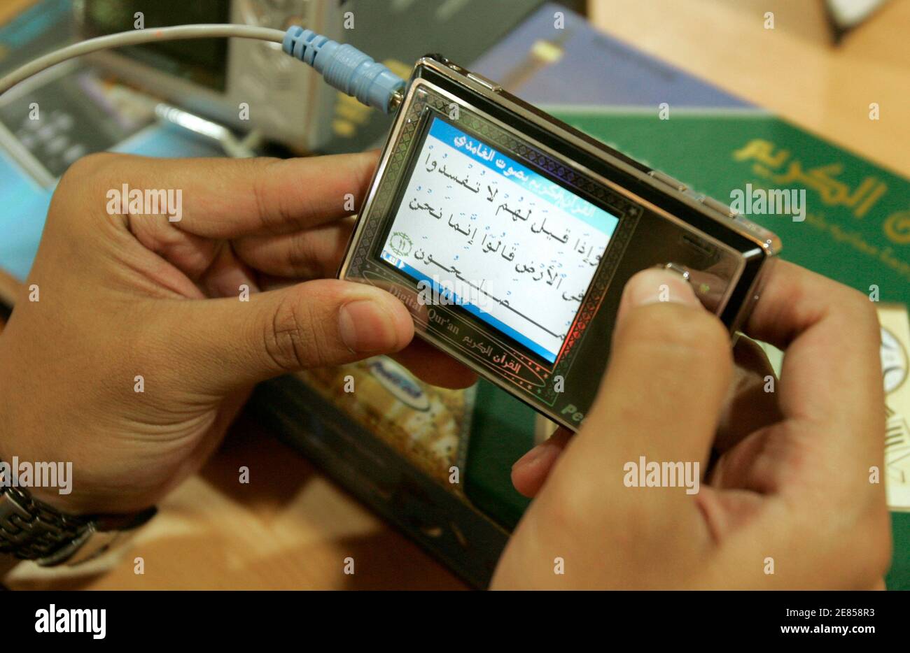 An Indonesian youth reads the Koran from a digital player at a book shop in Jakarta, September 20, 2007. Digital Koran is increasingly popular in Indonesia, the world's most populous Muslim country, where such gadgets sell especially well during the Islamic fasting month of Ramadan when religious fervour is high and reading the scripture is an essential part of the observance. Picture taken September 20, 2007.   REUTERS/Crack Palinggi (INDONESIA) Stock Photo