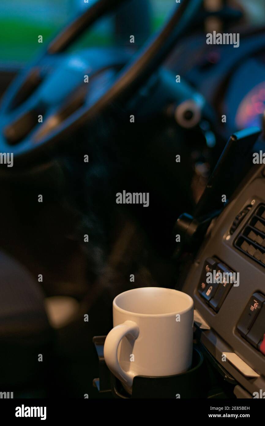 Steaming cup of coffee on the dashboard of a truck. Stock Photo