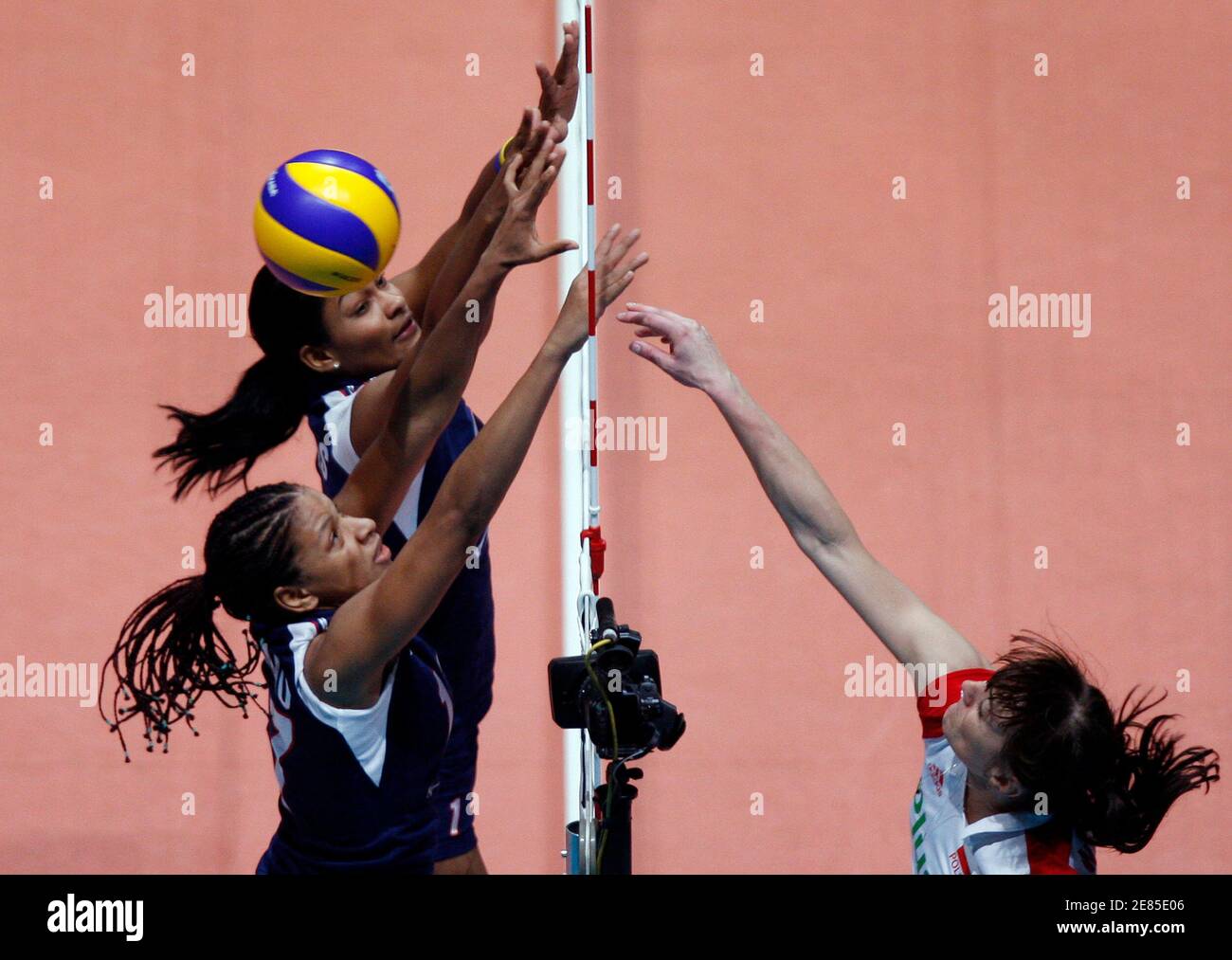 Annerys Vargas Valdez (top L) and Altagracia Mambru of the Dominican Republic reach for the ball against Anna Wozniakowska (R) of Poland during their FIVB World Grand Prix women's volleyball tournament in Hong Kong August 16, 2009. REUTERS/Tyrone Siu    (CHINA SPORT VOLLEYBALL) Stock Photo