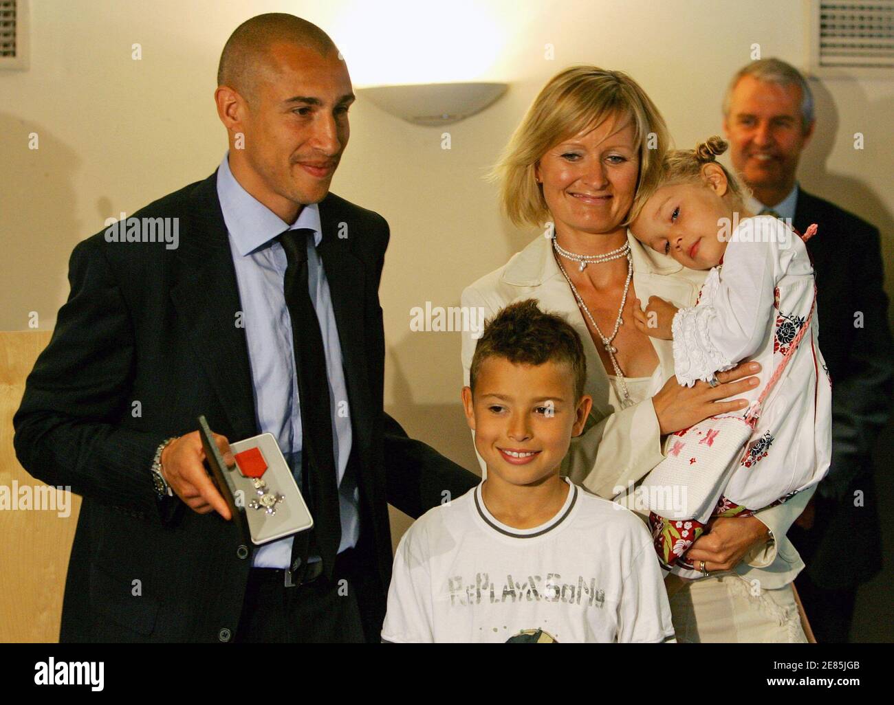 Barcelona's Henrik Larsson (L) from Sweden shows his Member of the Order of  the British Empire (MBE) medal with his wife Magdalena and children Jordan  (C) and Janelle (R) at the Nou