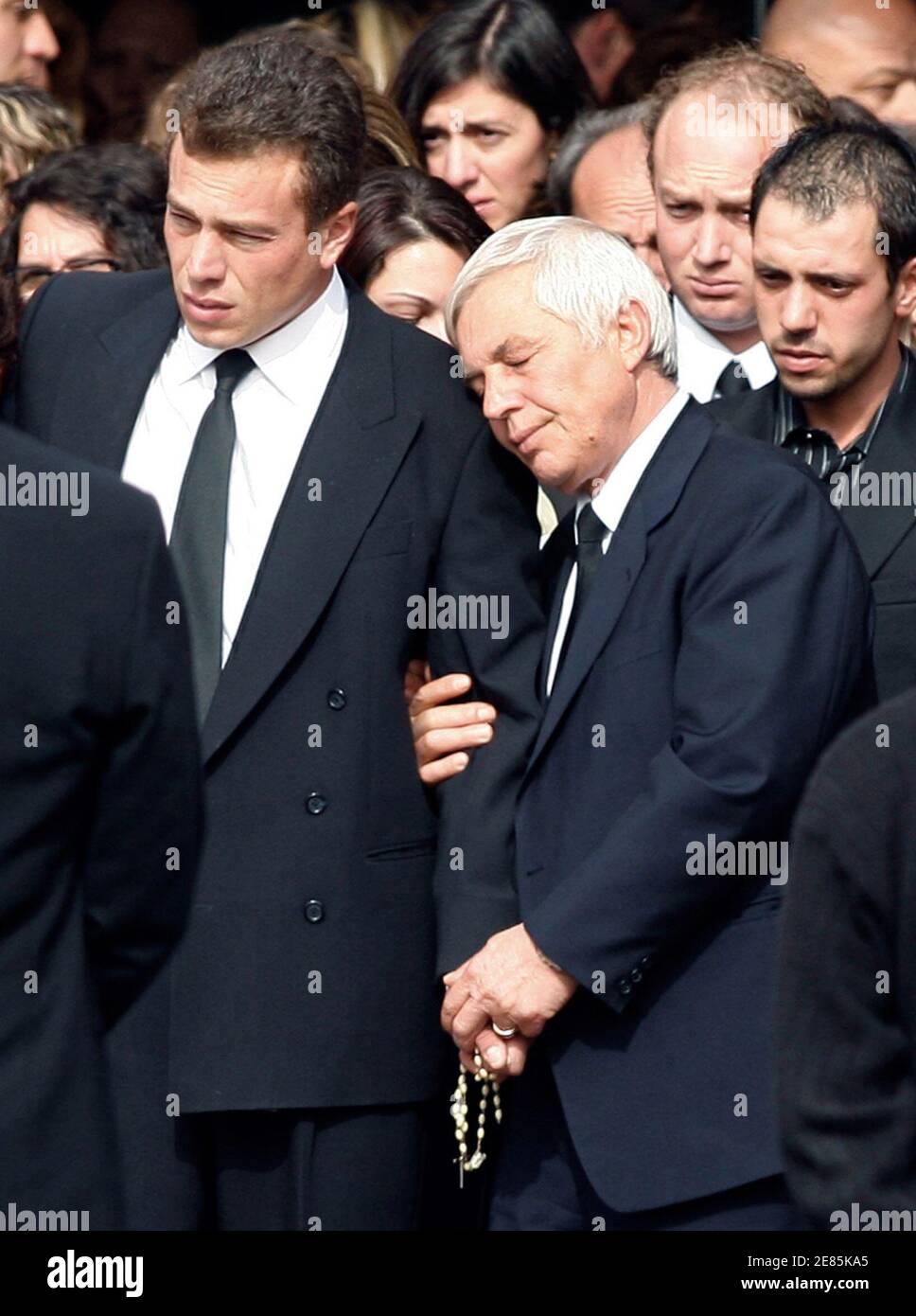 A relative comforts Leo Campione (L) as Campione leaves a funeral