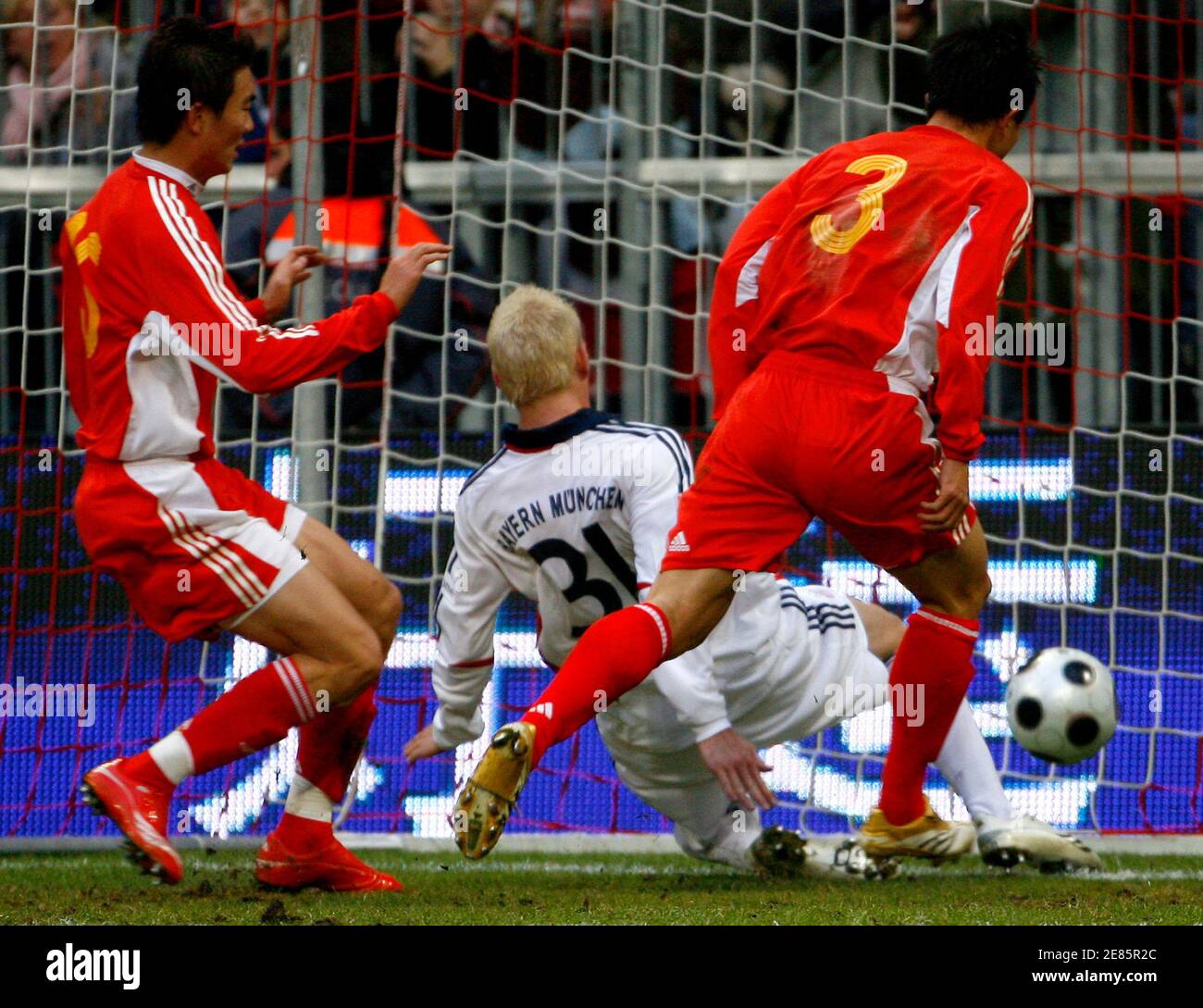 Bayern Munich's Bastian Schweinsteiger (C) scores his first goal against Xiang Sun (R) and Lin Dai of the Chinese Olympic team during their friendly soccer match in Munich, January 12, 2008.   REUTERS/Alexandra Beier (GERMANY) Stock Photo
