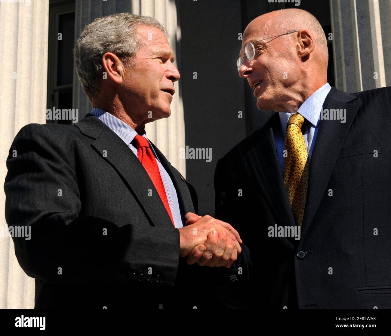 U.S. President George W. Bush (L) shakes hands with Treasury Secretary Henry Paulson as he departs the Treasury Building after thanking Treasury workers for their efforts after the House passed the $700 billion financial rescue legislation,  in Washington October 3, 2008.       REUTERS/Mike Theiler  (UNITED STATES) Stock Photo