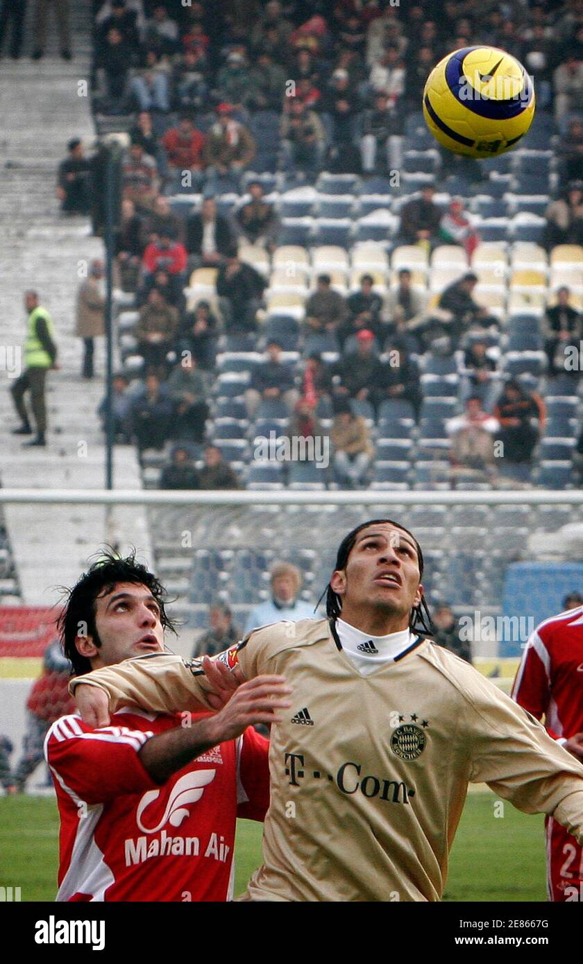 Sheic Rezaei (L) of Iran's Perspolis battles for the ball with Paolo Guerrero of Germany's Bayern Munich during their friendly soccer match in Tehran January 13, 2006. Bayern Munich won the match 2-1. REUTERS/Raheb Homavandi Stock Photo