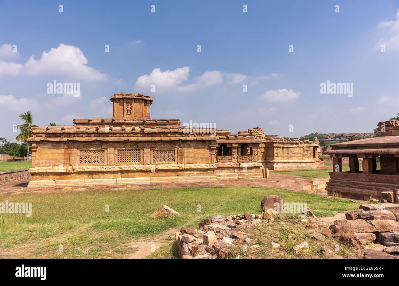 Aihole, Karnataka, India - November 7, 2013: Lad Khan or Chalukya Shiva Temple among other brown stone sanctuary buildings under blue cloudscape and w Stock Photo