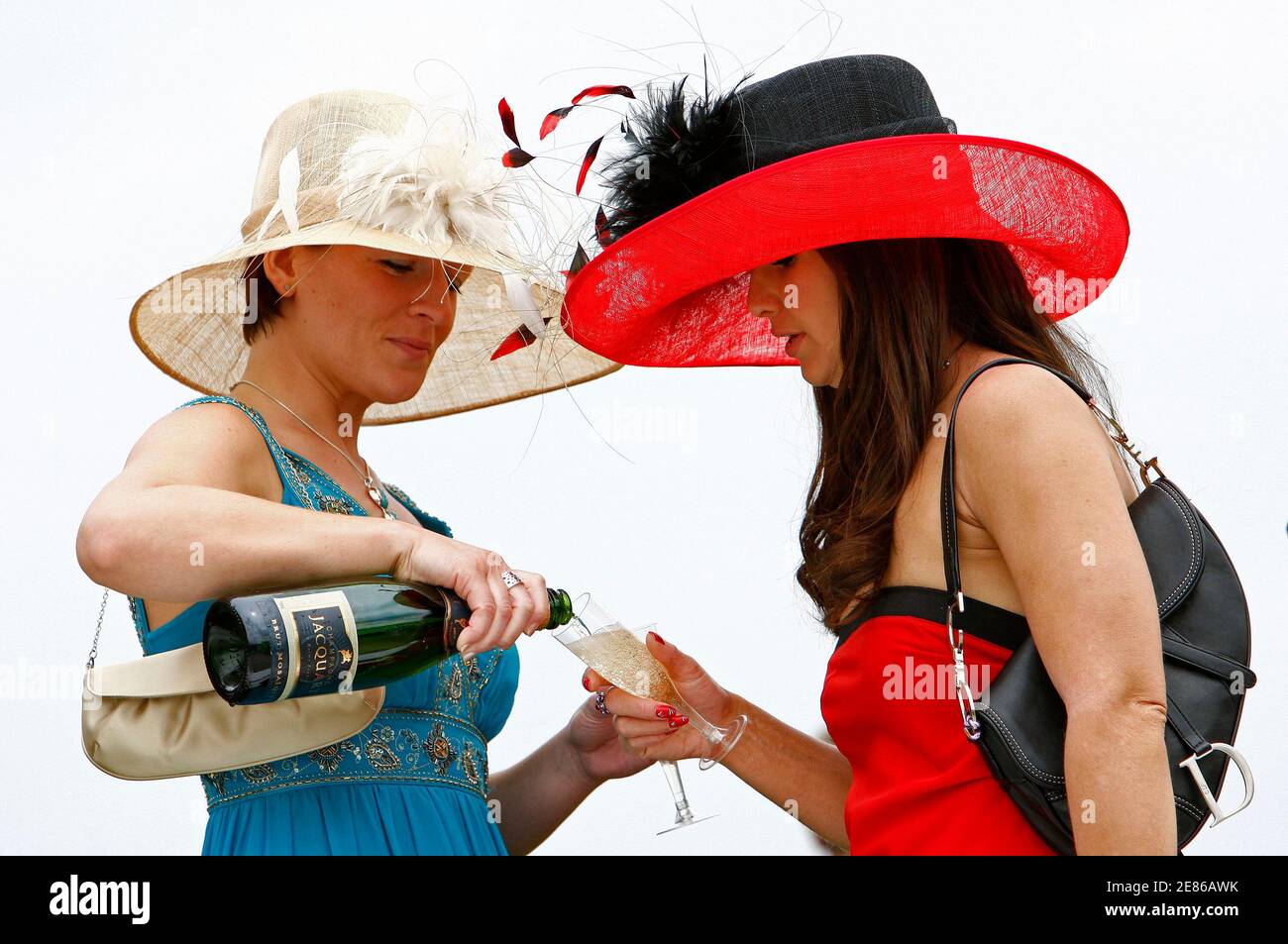 Racegoers drink champagne during Ladies day at the Epsom Derby Festival at Epsom Downs in Surrey, southern England June 6, 2008. REUTERS/Alessia Pierdomenico (BRITAIN) Stock Photo